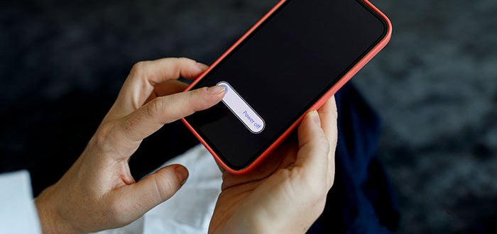 A person turning off their cellular phone