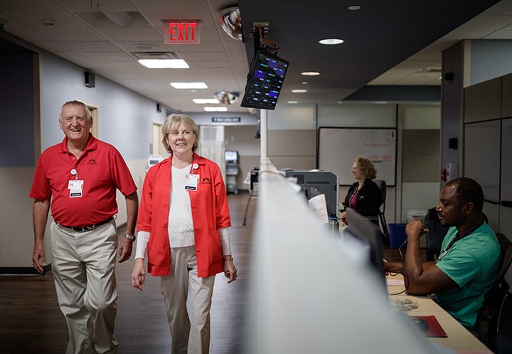Older male and female wearing read shirts in hospital