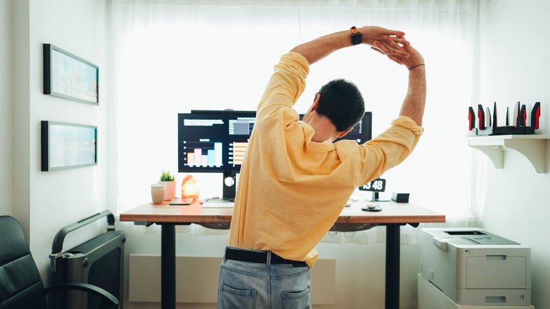 Man working at home, stretching