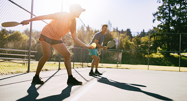 man and woman playing pickleball